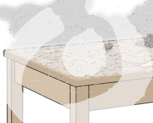 Auf einem Tisch liegt Staub. In der Luft darüber ist eine graue Wolke.