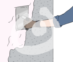 Eine Hand hält eine Putzkelle gegen eine halb verputzte Wand.