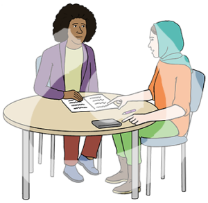 Zwei Frauen sitzen an einem Tisch. Eine Frau hat eine dunkle Hautfarbe. Die andere Frau hat eine helle Hautfarbe und trägt ein Kopftuch. Sie zeigt auf ein aufgeschlagenes Heft auf dem Tisch.
