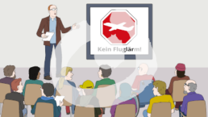 Ein Mann steht vor Publikum und erklärt etwas. Neben ihm ist ein großer Bildschirm mit einem rot weißen Zeichen. In der Mitte ist ein Flugzeug.